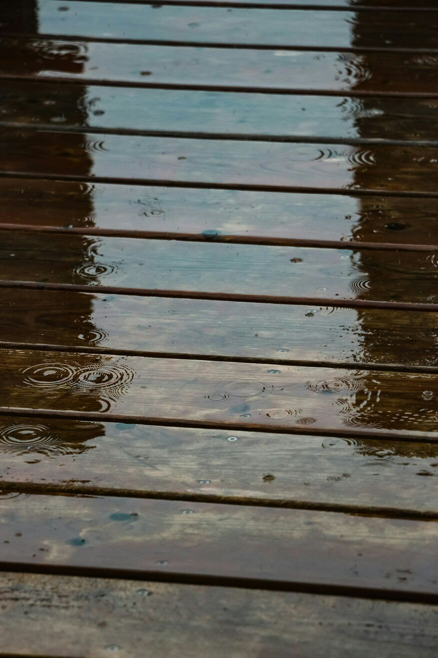 A close-up image shows a deck covered with water from a rainstorm.